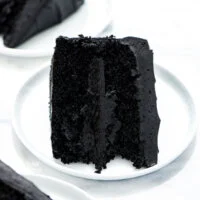 a slice of gluten free black velvet cake on a small round white plate