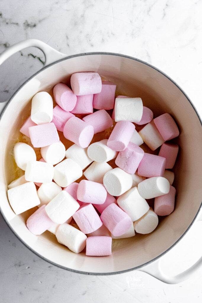 marshmallows in a large white dutch oven with melted butter