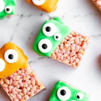 Monster Halloween Rice Krispie Treats dipped in orange and green candy melts and decorated with different sized candy eyes