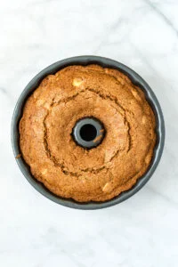 a baked gluten free apple cake in a bundt pan ready to cool