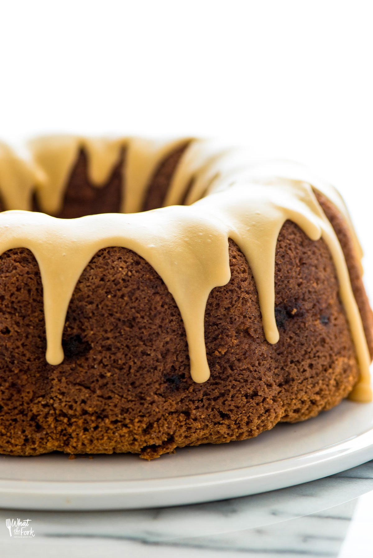 close up of a gluten free apple bundt cake topped with maple glaze.