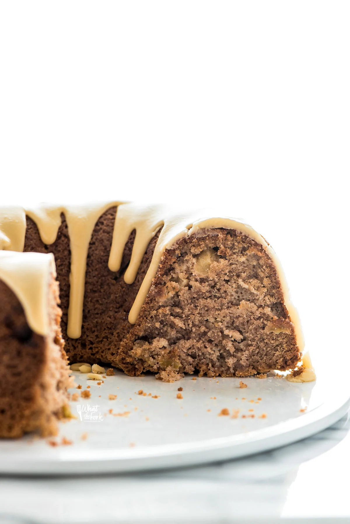 a gluten free apple cake on a flat white cake plate that has been sliced