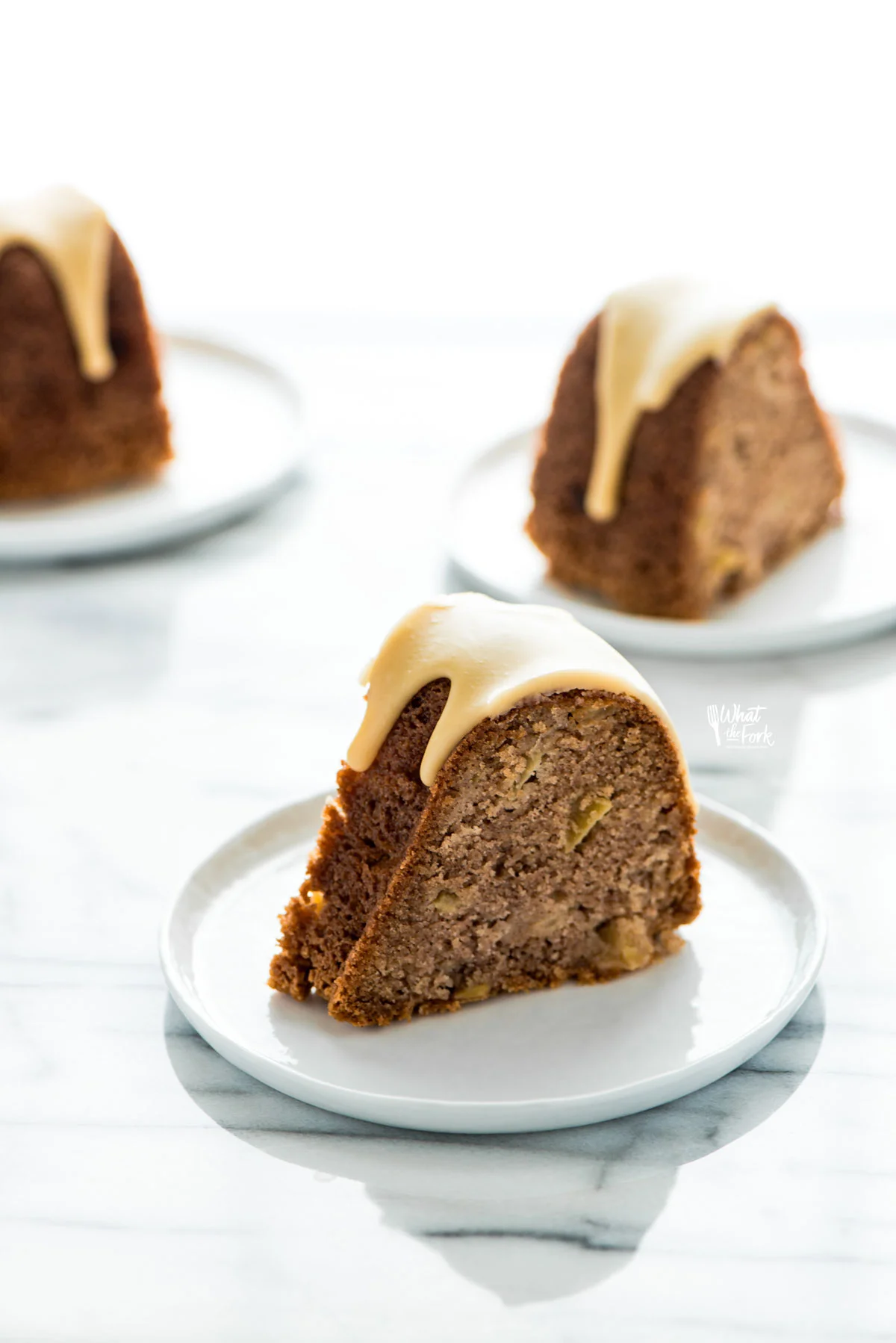Slices of gluten free apple cake on small white plates ready to serve