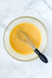 wet ingredients whisked together in a glass bowl to make gluten free apple cake