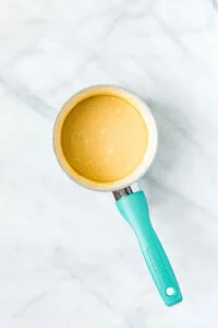 maple glaze in a small white saucepan with a aqua blue handle