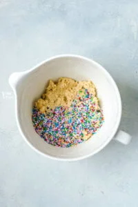 rainbow sprinkles on top of sugar cookie dough to make gluten free sugar cookies with sprinkles