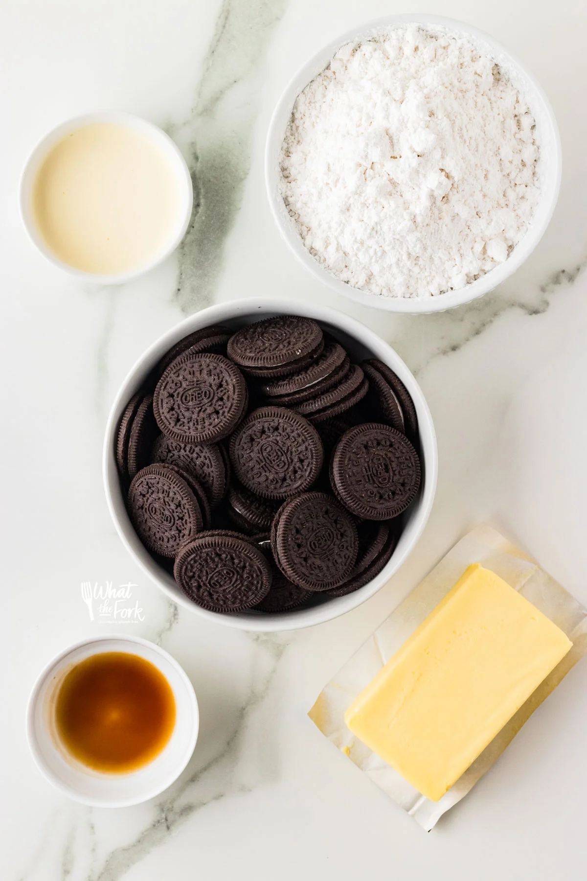 ingredients in individual bowls to make a Cookies and Cream Frosting recipe