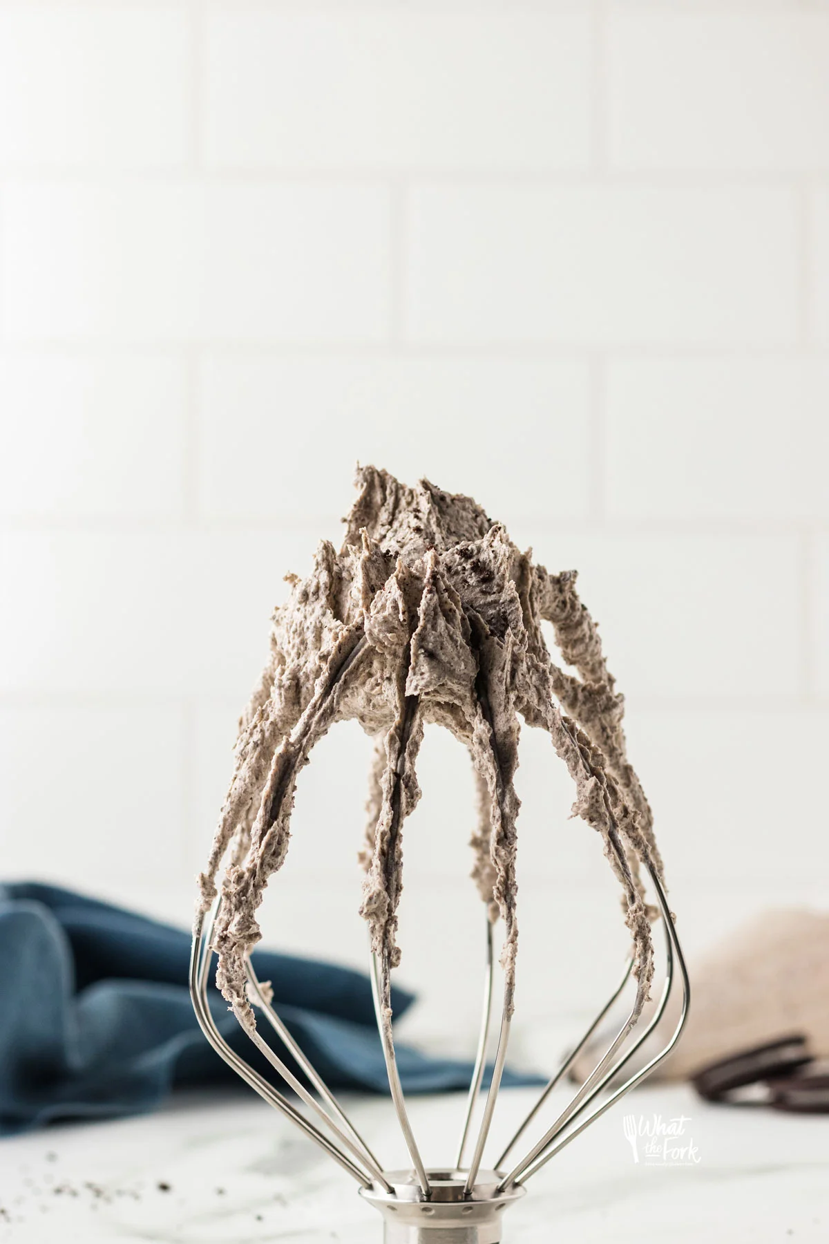 Cookies and Cream Frosting on a the tip of a Kitchenaid Whisk that's standing up on a counter