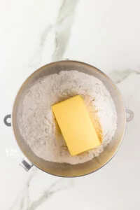 powdered sugar and a block of butter in a large silver bowl