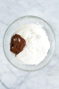 nutella in a large, clear glass bowl with whipped cream