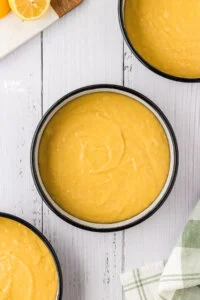 gluten free lemon cake batter in round cake pans ready to be baked