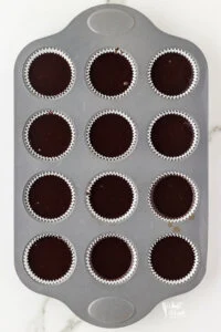gluten free chocolate cupcake batter in a white paper lined muffin tin ready to be baked
