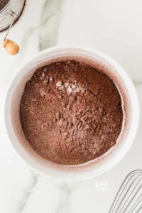 dry ingredients added to a white bowl to make gluten free chocolate cupcakes
