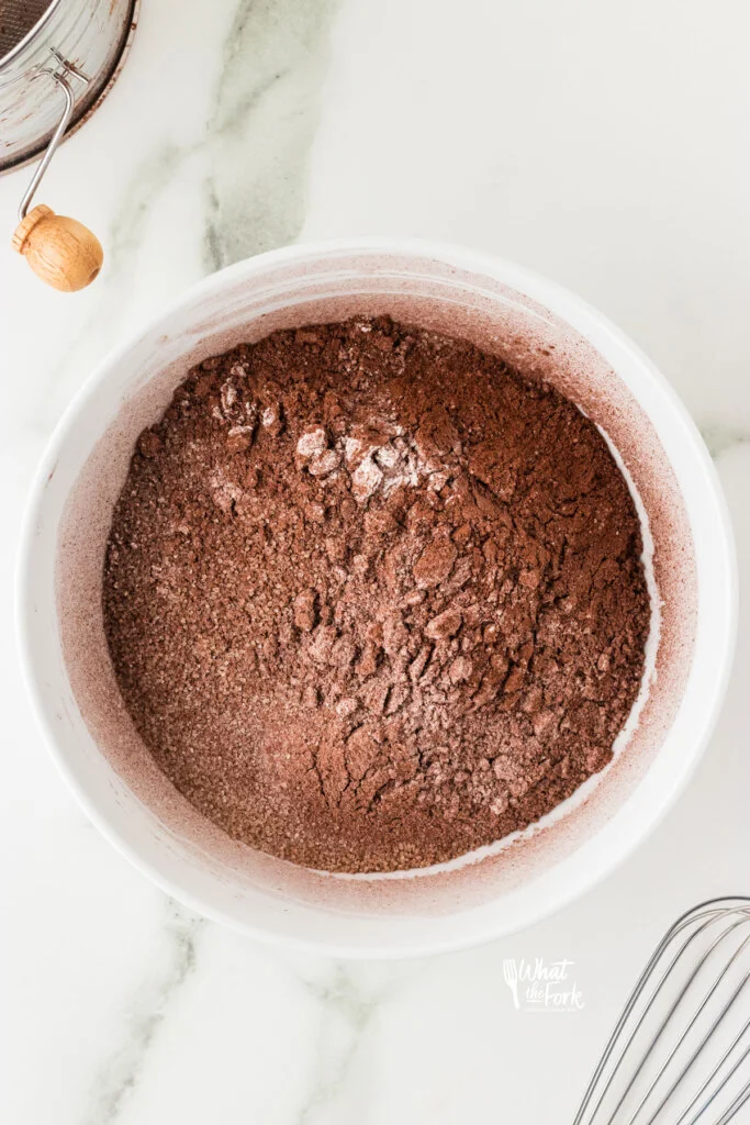 dry ingredients added to a white bowl to make gluten free chocolate cupcakes