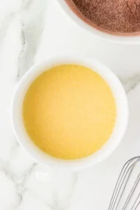 wet ingredients whisked together in a white bowl to make gluten free chocolate cupcakes