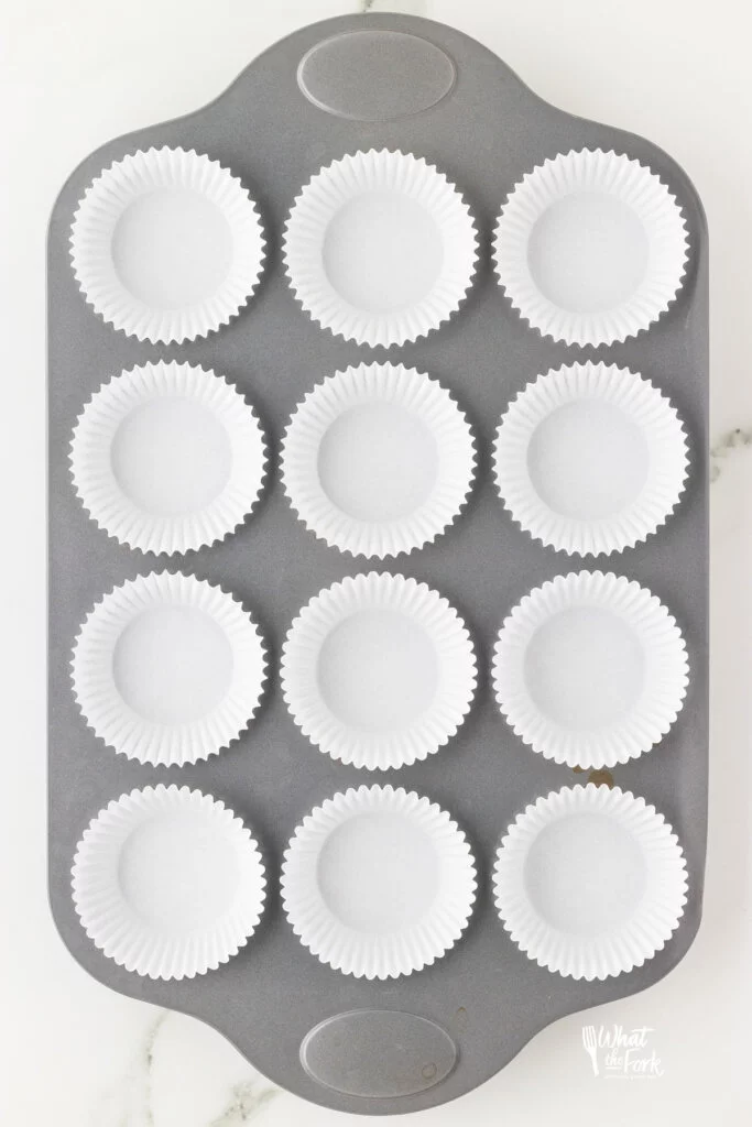 white cupcake liners in a 12-cup standard muffin tin
