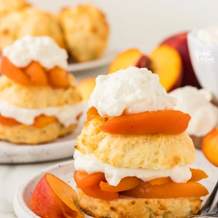 Mom’s Gluten Free Peach Shortcake with Biscuits served on a round white pottery plate with a silver fork