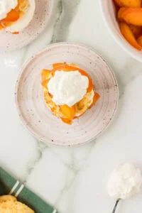 overhead shot of a gluten free peach shortcake on a round white plate