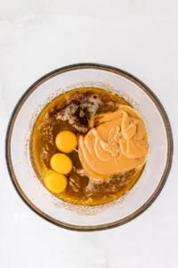 wet ingredients including eggs, vanilla, and peanut butter in a glass bowl to make gluten free peanut butter cookies