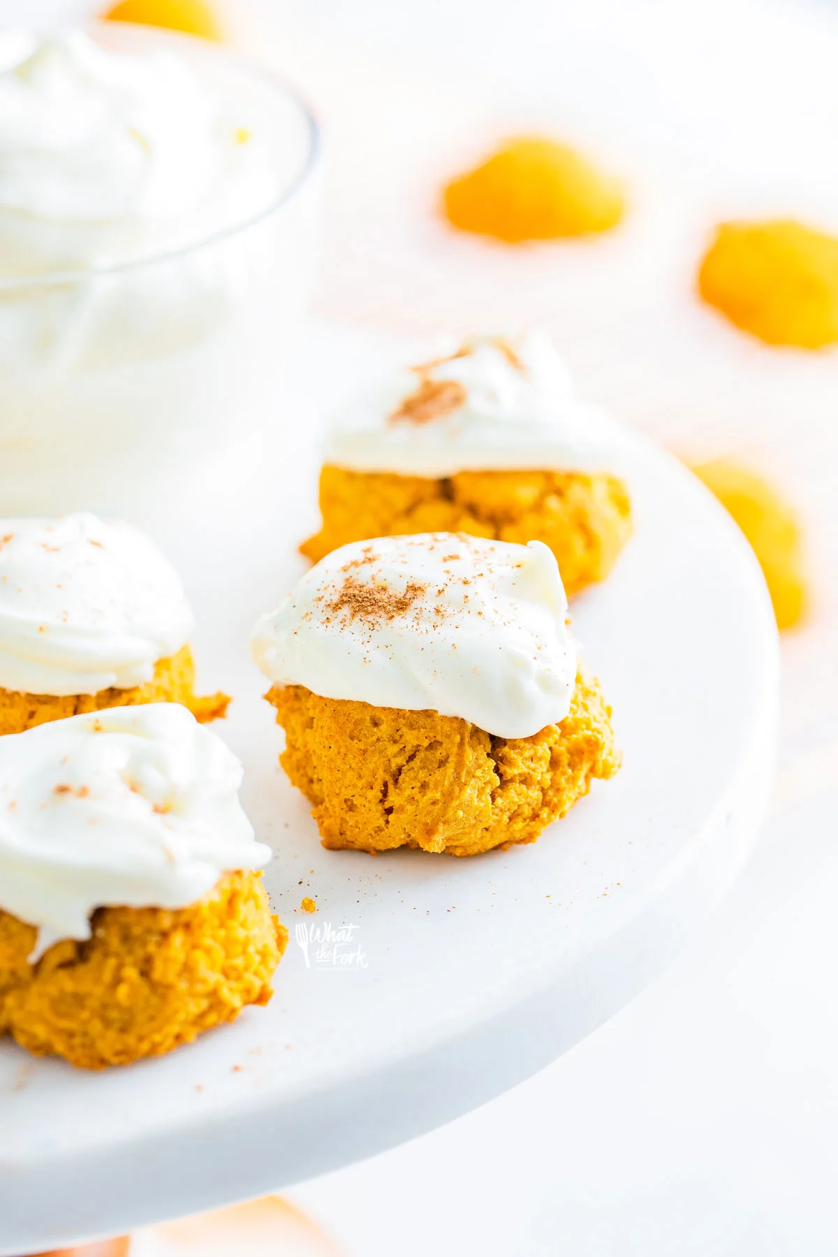 baked No Chill Gluten Free Pumpkin Cookies with Cream Cheese Frosting on a white cake stand ready to be served
