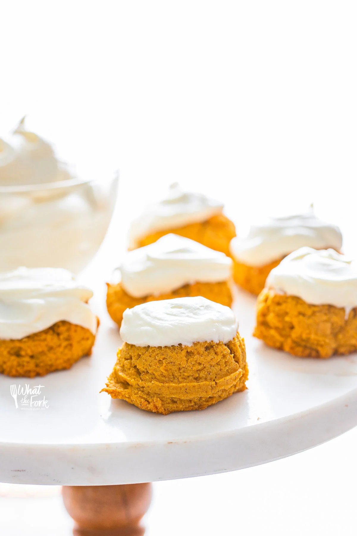 No Chill Gluten Free Pumpkin Cookies with Cream Cheese Frosting on a white and wood cake stand