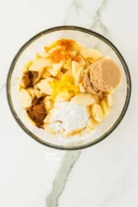 apples, spices, cornstarch, citrus zest, and brown sugar in a large glass bowl