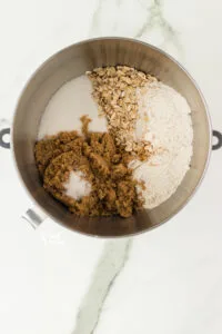 gluten free oats, gluten free flour, spices, and brown sugar in a a silver bowl for a stand mixer