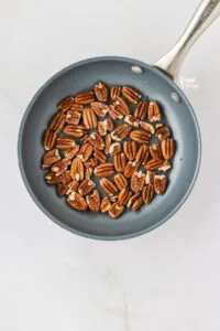 overhead shot of raw pecans halves in a non-stick skillet