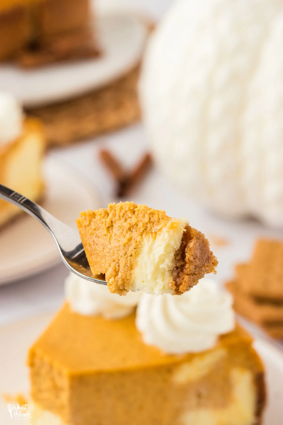 a bite of Layered Pumpkin Cheesecake with a Gluten Free Crust on a silver fork