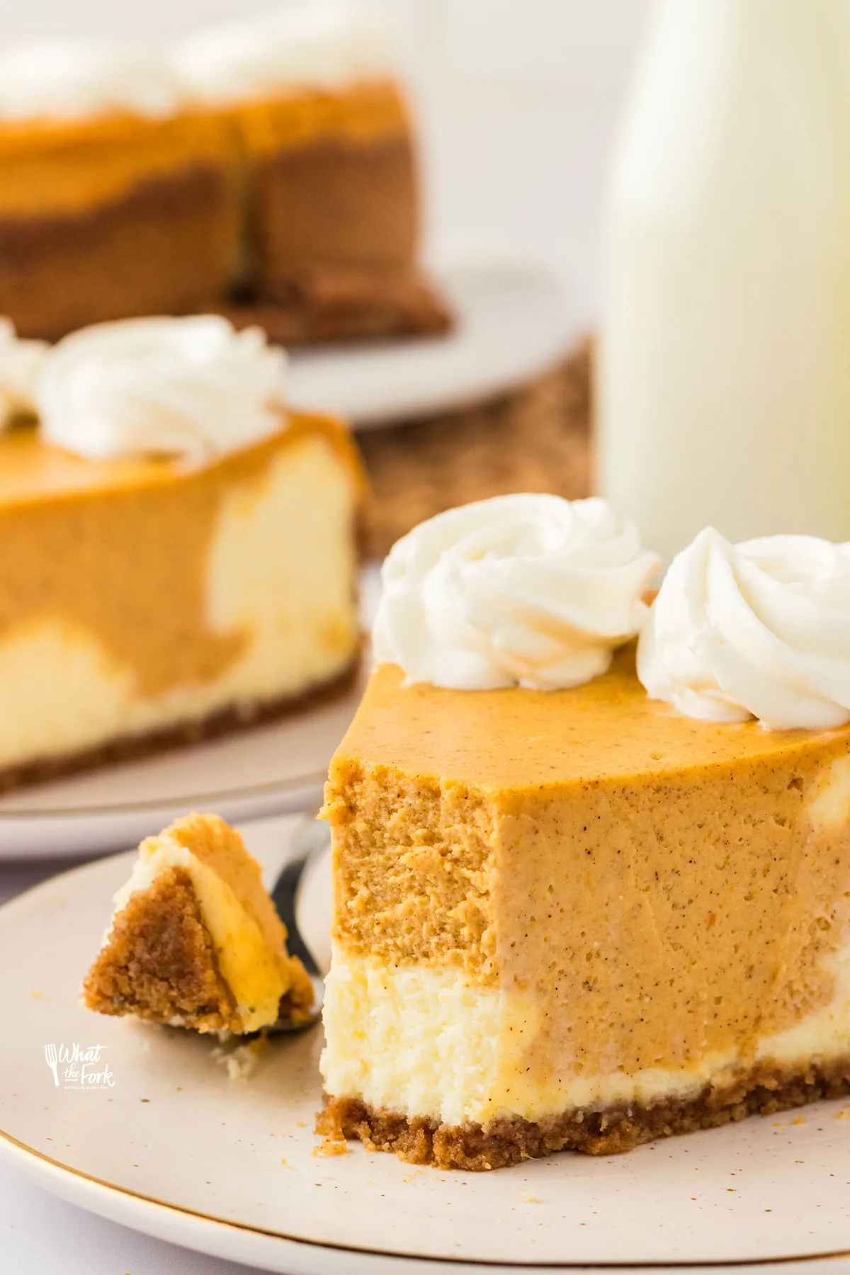 a slice of Layered Pumpkin Cheesecake with a Gluten Free Crust on a small round white plate