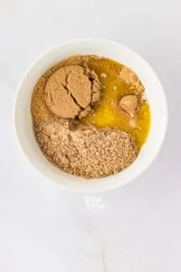 ground pecans, ground graham crackers, and melted butter in a white bowl