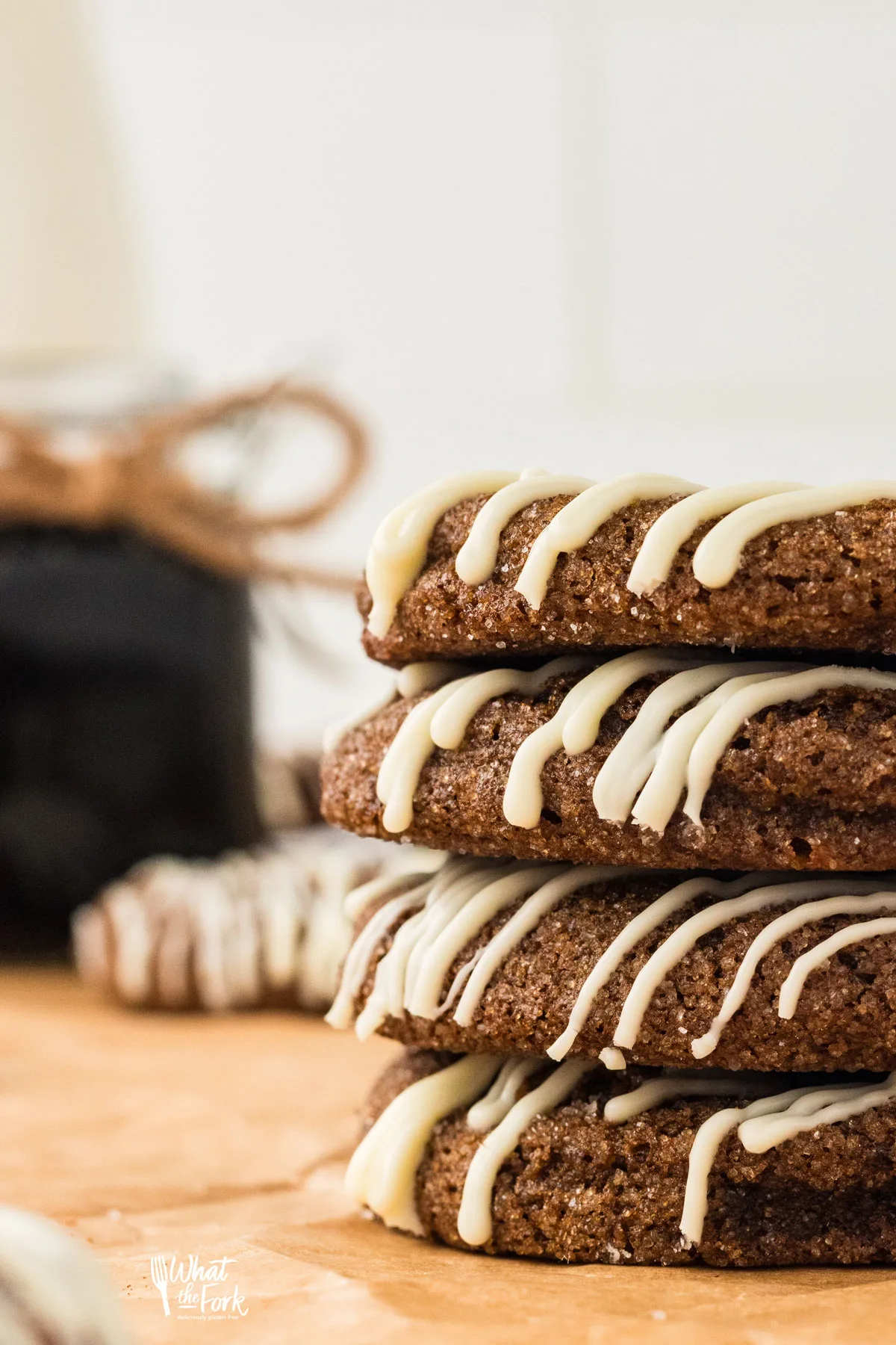 soft and chewy Gluten Free Ginger Cookies made with double molasses are drizzled in white chocolate and stacked in a group of 4