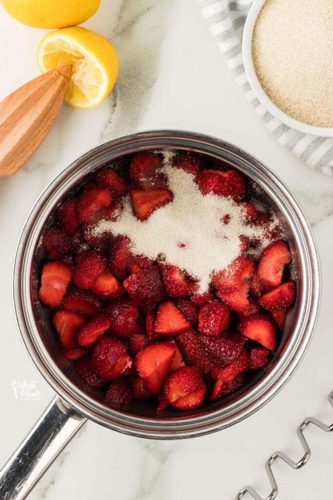 strawberries, sugar, and fresh lemon juice in a silver saucepan