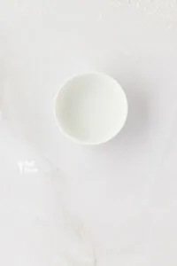 baking soda dissolved in water in a small round white bowl