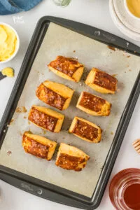 baked gluten free pretzel biscuits on a parchment paper lined baking sheet