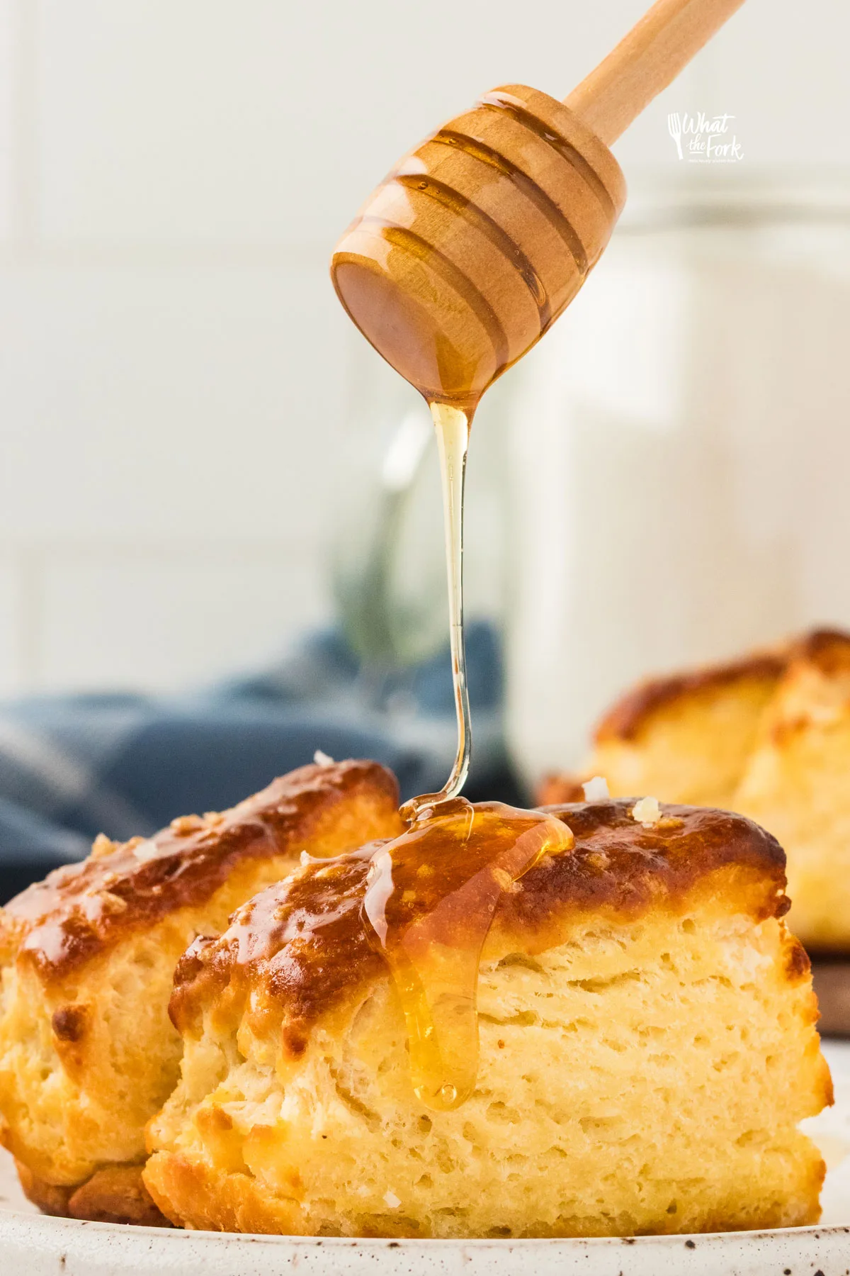 a honey ladle drizzling honey on top of a gluten free pretzel biscuit