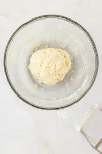 gluten free biscuit dough in kneaded into a ball in a large glass bowl