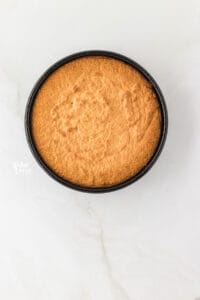 baked almond flour cake in a round, dark cake pan
