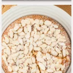 Overhead shot of an almond flour cake with one slice cut, ready to be served. Image has text included with color block for Pinterest