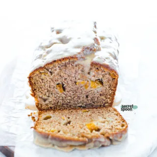 a loaf of Gluten Free Peach Bread with Cinnamon Almond Glaze sliced and ready to serve