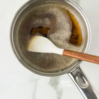 brown butter in a small silver saucepan with a small white spatula with a wood handle