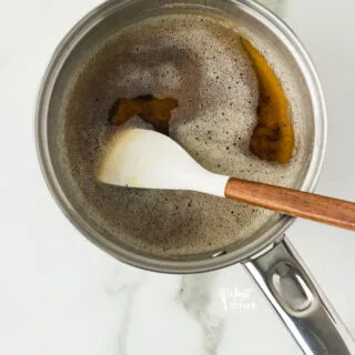 brown butter in a small silver saucepan with a small white spatula with a wood handle
