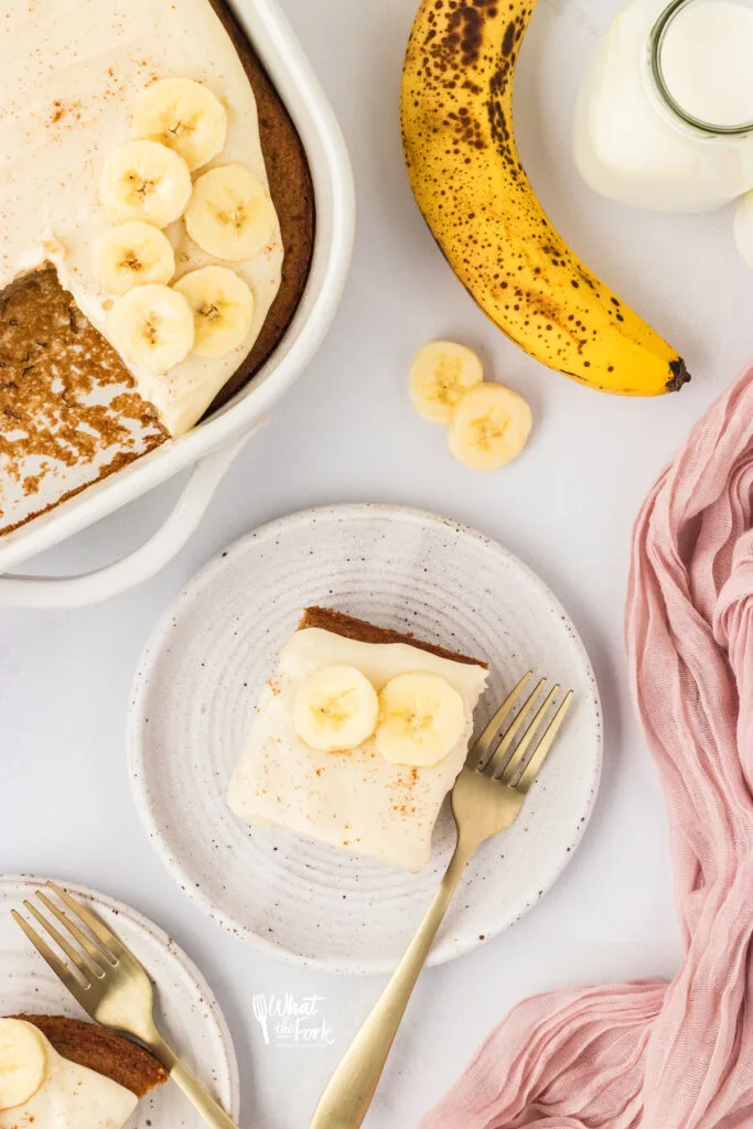 overhead shot of a slice of Gluten Free Banana Cake on a around white plate with a gold fork