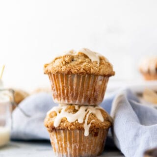 2 Big, bakery style Gluten Free Chocolate Chip Oatmeal Muffins with oatmeal streusel and maple glaze stacked on top of each other