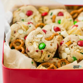Gluten Free Christmas Kitchen Sink Cookies in a red cookie tin lined with brown parchment paper