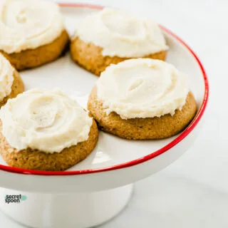 Soft Gluten Free Eggnog Cookies on a white cake stand with red trim