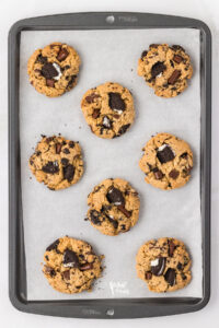 baked Gluten Free Oreo Chocolate Chip Cookies on a silver cookie sheet lined with white parchment paper