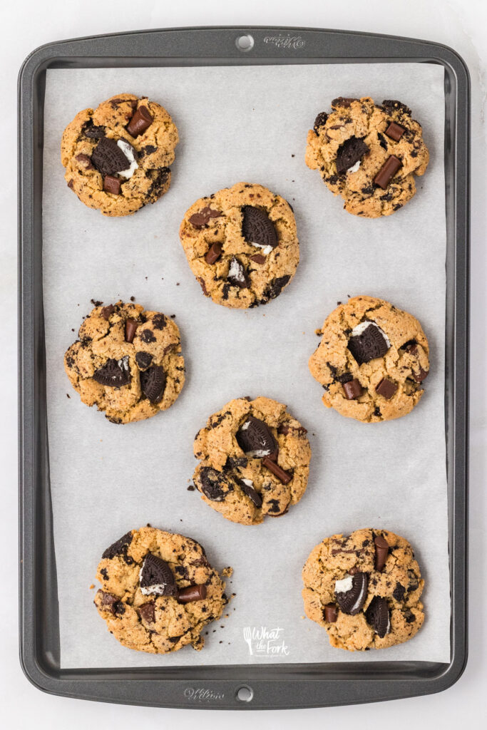 baked Gluten Free Oreo Chocolate Chip Cookies on a silver cookie sheet lined with white parchment paper