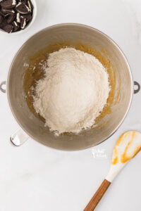 dry ingredients added to a large silver bowl with wet ingredients to make Gluten Free Oreo Chocolate Chip Cookies